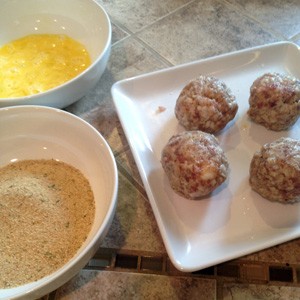 Sausage covered eggs ready to coat